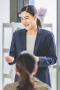 Closeup shot of Asian pretty happy cheerful female businesswoman intern trainee in casual suit standing smiling in company office Royalty Free Stock Photo