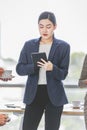 Closeup shot of Asian pretty happy cheerful female businesswoman intern trainee in casual suit standing smiling in company office Royalty Free Stock Photo