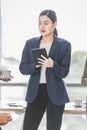 Closeup shot of Asian pretty happy cheerful female businesswoman intern trainee in casual suit standing smiling in company office Royalty Free Stock Photo
