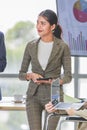 Closeup shot of Asian pretty happy cheerful female businesswoman intern trainee in casual suit standing smiling in company office Royalty Free Stock Photo