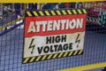 Closeup shot of an attention high voltage sign on a grid fence