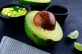 Closeup shot of avocado cut in half and lime slices on a table Royalty Free Stock Photo