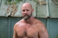 Closeup shot of a bald bearded man with no shirt