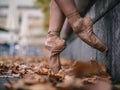 Closeup shot of a ballet dancer& x27;s feet on the street with fallen autumn leaves. Royalty Free Stock Photo