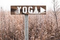 Closeup shot of a banner saying yoga in the middle of the field covered with little sn