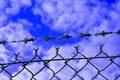 Closeup shot of a barbed wire steel fencing on a cloudy sky Royalty Free Stock Photo