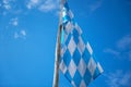 Closeup shot of a Bavarian flag on a pole with a clear blue sky background Royalty Free Stock Photo