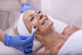 Closeup shot of a beautiful female in beauty salon during mesotherapy procedure with derma roller