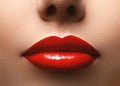 Closeup shot of beautiful full lips with red glossy make-up. Perfect bright lipstick. Plastic surgery or makeup concept Royalty Free Stock Photo