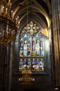 Closeup shot of the beautiful stained glass window next to big chandeliers in Votive Church, Vienna