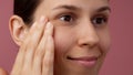 Closeup shot of beautiful young girl touching her face soft skin with no makeup and smiling. Looking away from camera. Royalty Free Stock Photo