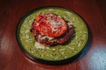 Closeup shot of beautifully served meat dish on a green plate