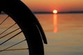Closeup shot of a bicycle wheel silhouette on an amazing sunset background