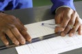 Closeup shot of a black architect's hands designing a building plans on paper Royalty Free Stock Photo