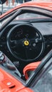 Closeup shot of a black Ferrari F40 Steering Wheel of a red car