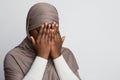 Closeup Shot Of Black Muslim Woman In Hijab Covering Face With Hands