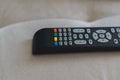 Closeup shot of a black plastic television remote on the sofa Royalty Free Stock Photo