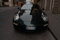 Closeup shot of a black Porsche parked on the side of a quiet street
