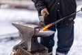 Closeup shot of a blacksmith hitting hot iron with a mallet outdoors