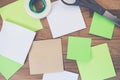 Closeup shot of blank sticky notes, a tape, and scissors on a wooden table Royalty Free Stock Photo