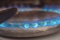 Closeup shot of blue fire from domestic kitchen stove top. Gas cooker with burning flames of propane gas. Industrial resources and Royalty Free Stock Photo