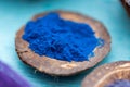 Closeup shot of blue food coloring powder in a small coconut plate Royalty Free Stock Photo