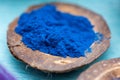 Closeup shot of blue food coloring powder in a small coconut plate Royalty Free Stock Photo