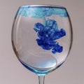 Closeup shot of blue ink dropping on a glass of water Royalty Free Stock Photo