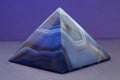 Closeup shot of a blue marble pyramid with a purple background Royalty Free Stock Photo