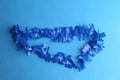 Closeup shot of a blue plastic party necklace on a blue background Royalty Free Stock Photo
