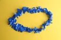 Closeup shot of a blue plastic party necklace on a yellow background Royalty Free Stock Photo