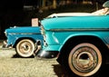 Closeup shot of a blue retro car with another old car in the background Royalty Free Stock Photo