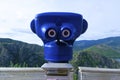 Closeup shot of a blue telescope looking towards the forested mountains Royalty Free Stock Photo