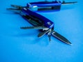 Closeup shot of a blue utility pocket plier on a blue surface