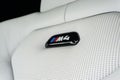 Closeup shot of a BMW M4 sign on white leather seats