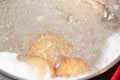 Closeup shot of boiling water with brown eggs on a stainless casserole