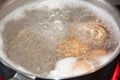 Closeup shot of boiling water with brown eggs on a stainless casserole