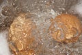 Closeup shot of boiling water with brown eggs on a stainless casserole