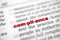 Closeup shot from the book of the red word 'compliance' divided by syllables Royalty Free Stock Photo