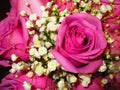 Closeup shot of a bouquet with bright pink roses and yellow lisianthus flowers