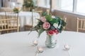 Closeup shot of a bouquet of elegant flowers in a glass vase surrounded by candles on the table Royalty Free Stock Photo