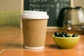 Closeup shot of a bowl of black olives and a cup of coffee on the table Royalty Free Stock Photo