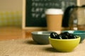 Closeup shot of a bowl of black olives on a wooden table Royalty Free Stock Photo