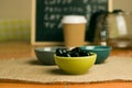 Closeup shot of a bowl of black olives on a wooden table Royalty Free Stock Photo