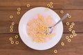 Closeup shot of a bowl full of regular cereal on a wooden table