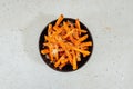 Closeup shot of a bowl of sweet potato fries on a white table Royalty Free Stock Photo