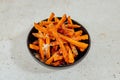 Closeup shot of a bowl of sweet potato fries on a white table Royalty Free Stock Photo