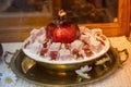 Closeup shot of a bowl of Turkish delight with a ceramic pomegranate figure on the center Royalty Free Stock Photo