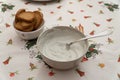 Closeup shot of a bowl of white sauce and biscuits on a dinner table