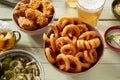 Closeup shot of bowls of onion rings, fried chicken wings, and salad, and two bottles of beer Royalty Free Stock Photo